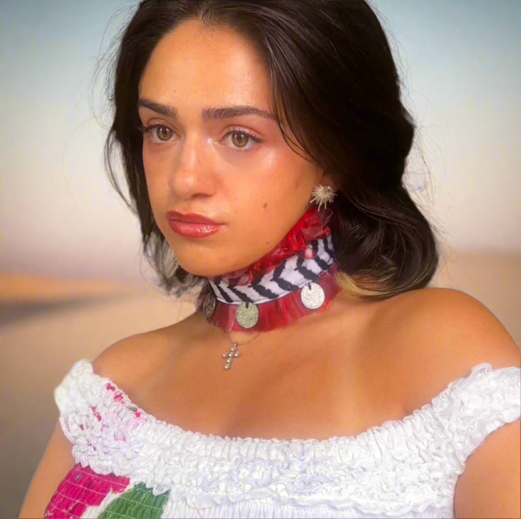 Woman wearing a statement necklace with coins around her neck with a white background